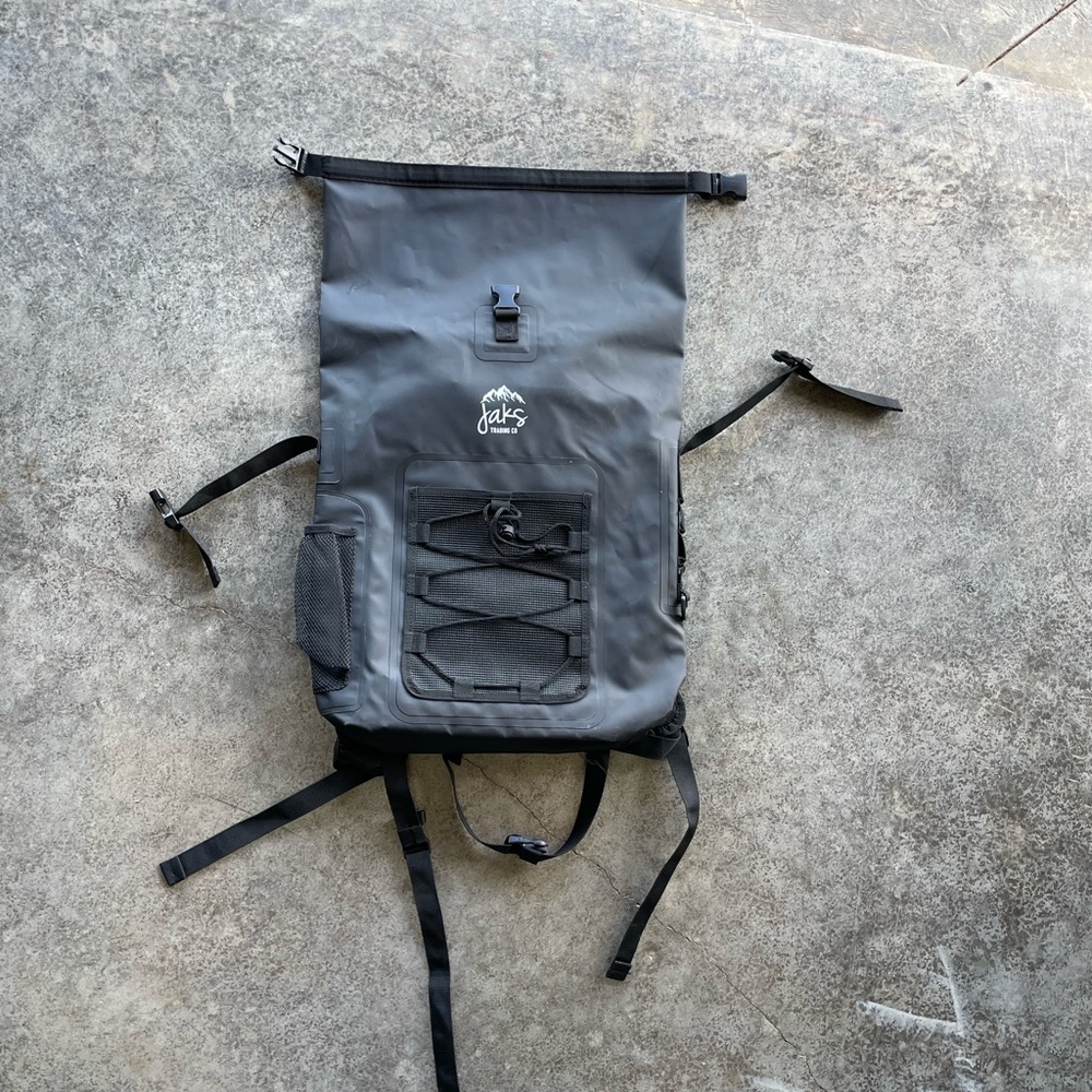 Black Tactical Backpack with Roll-Top Closure and MOLLE System hiking beach